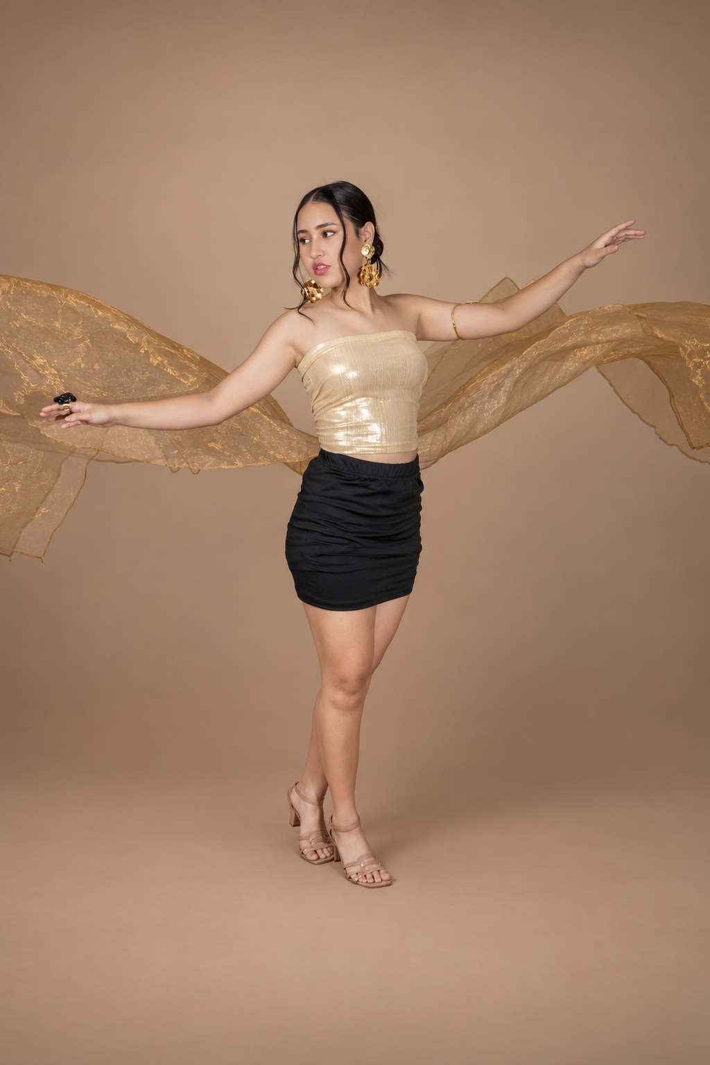 Thailiz Issabella con un conjunto dorado y negro y una tela dorada en movimiento